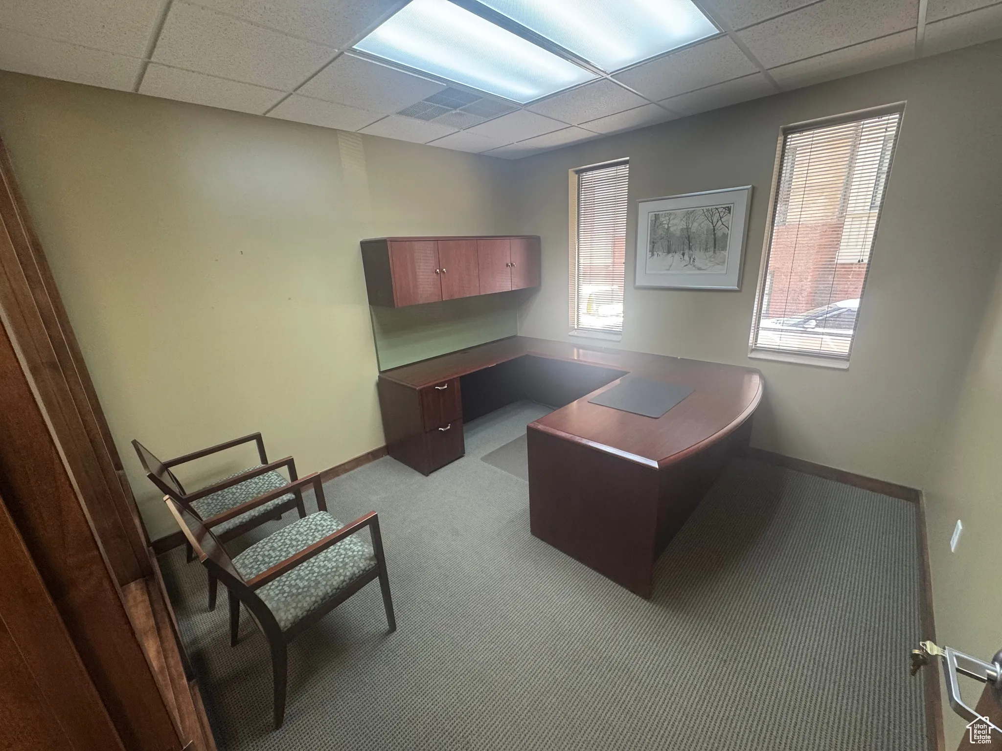 Home office with carpet floors and a drop ceiling