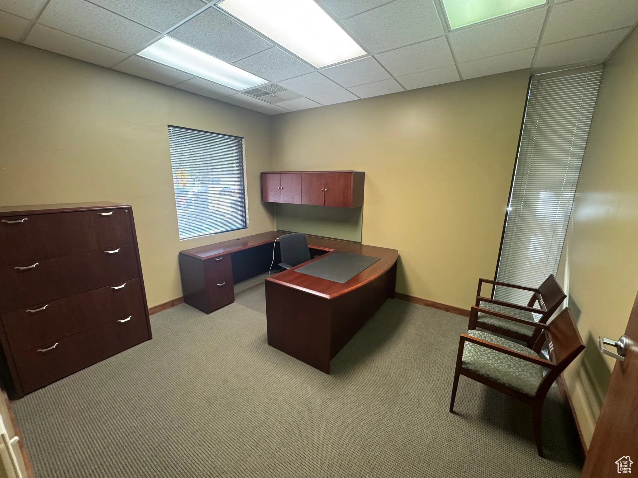 Office area with light colored carpet and a drop ceiling