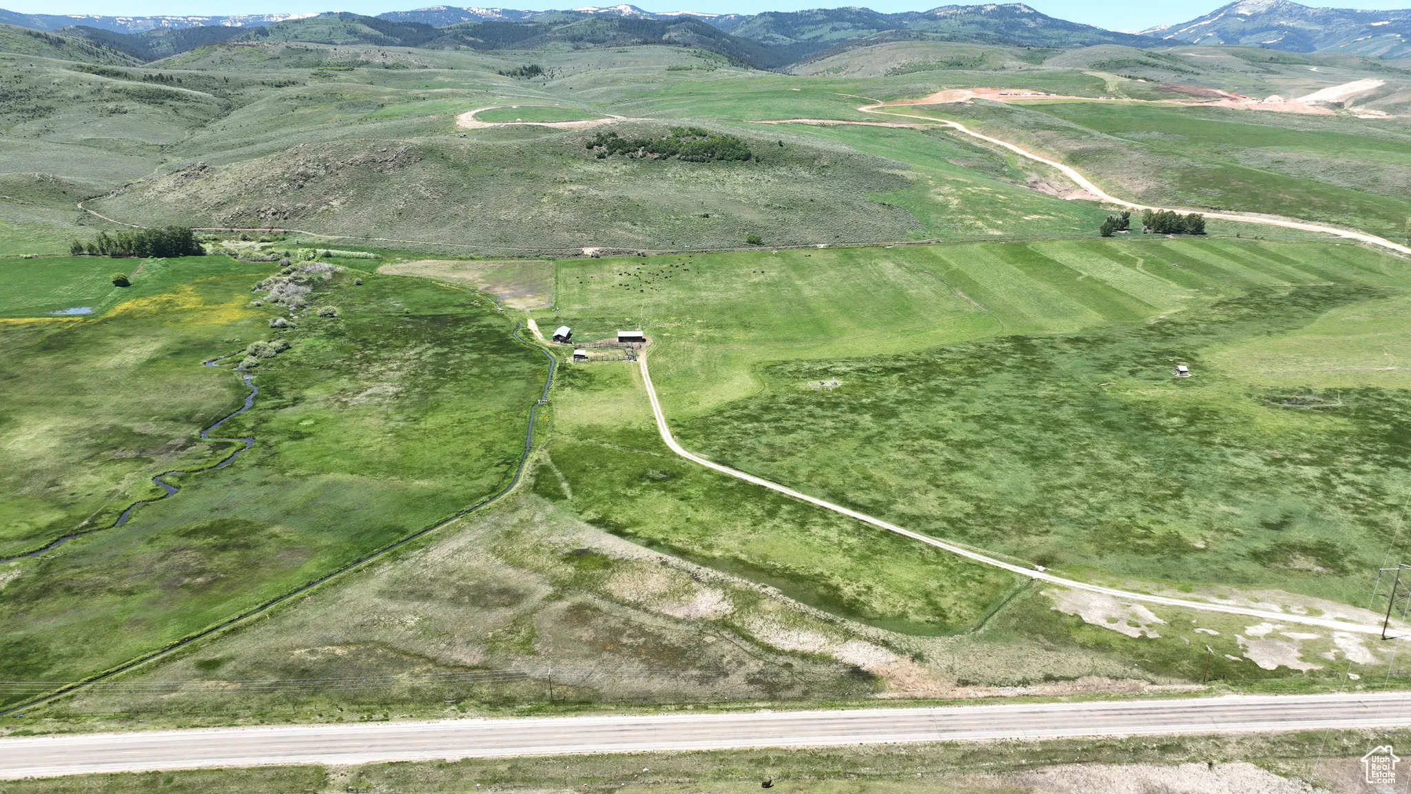 Aerial view of property and surrounding area featuring mountains and rural landscape