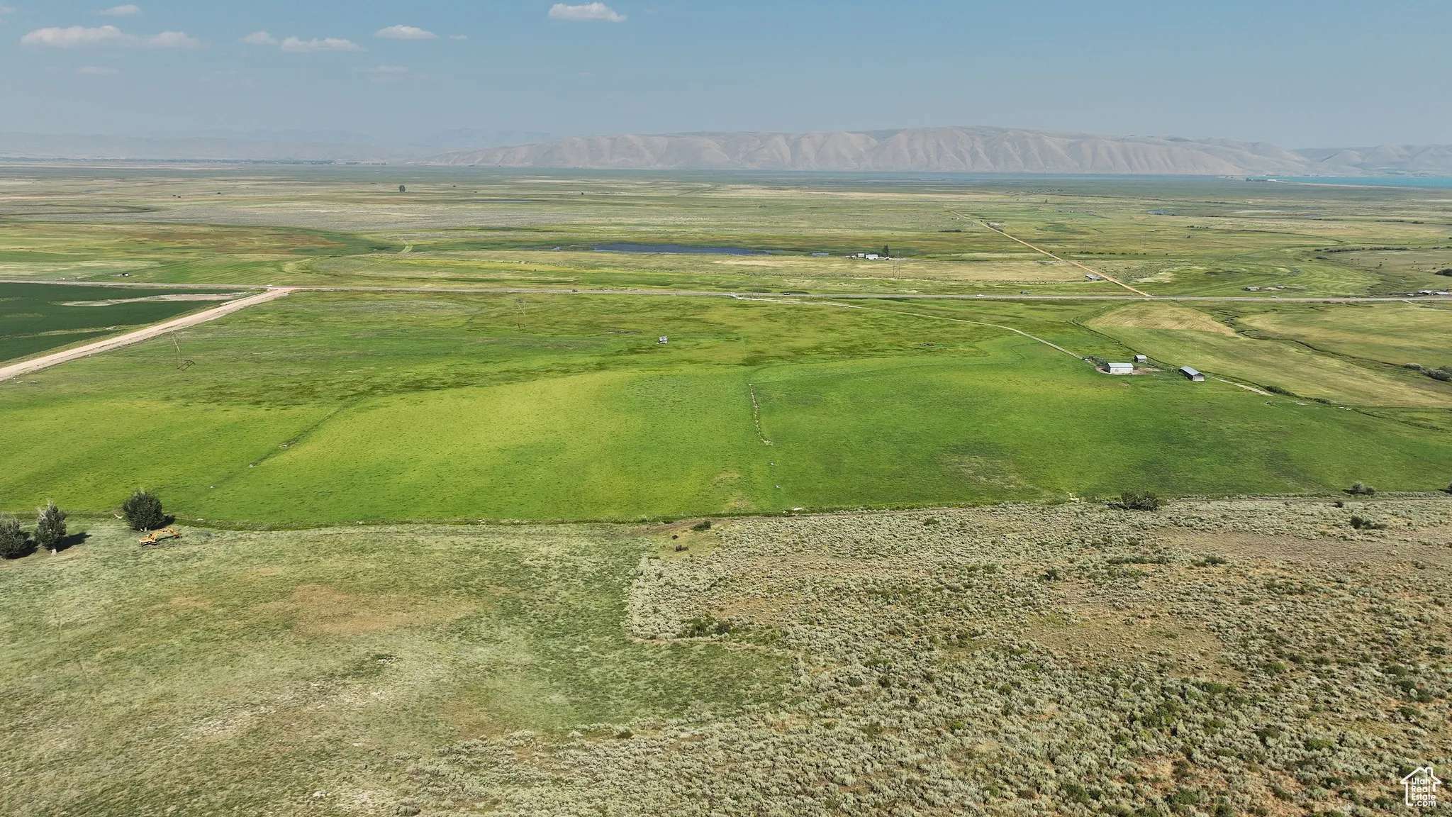 Aerial view of property and surrounding area featuring a mountain backdrop