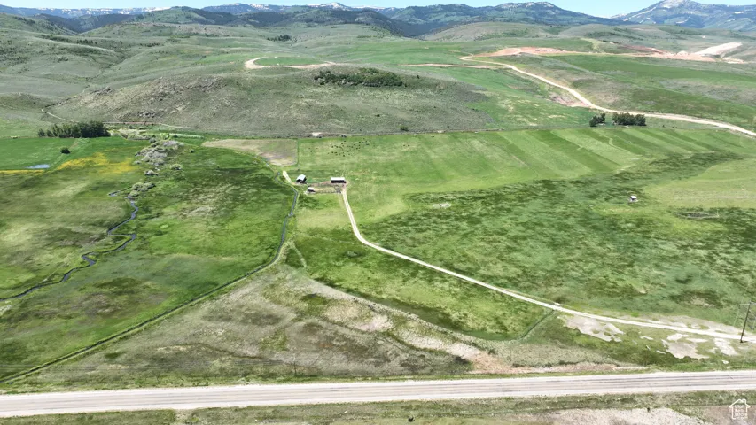 Aerial view of property and surrounding area featuring mountains and rural landscape