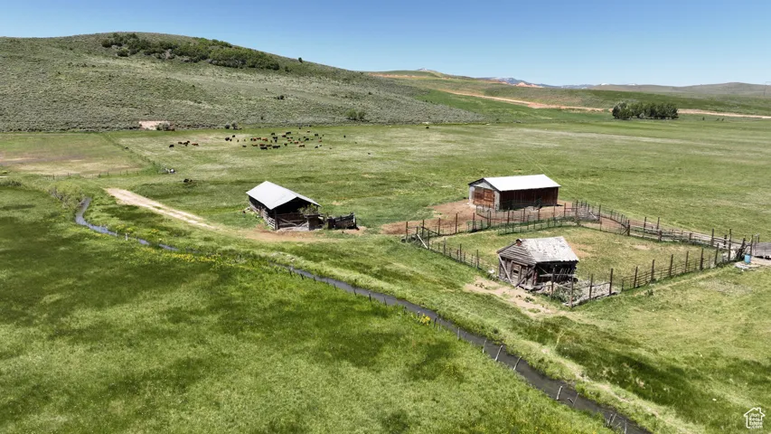 Overview of rural landscape featuring a pastoral area and a mountain backdrop