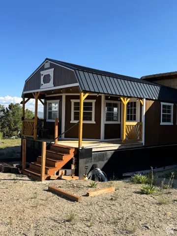 View of front of home with a porch and metal roof