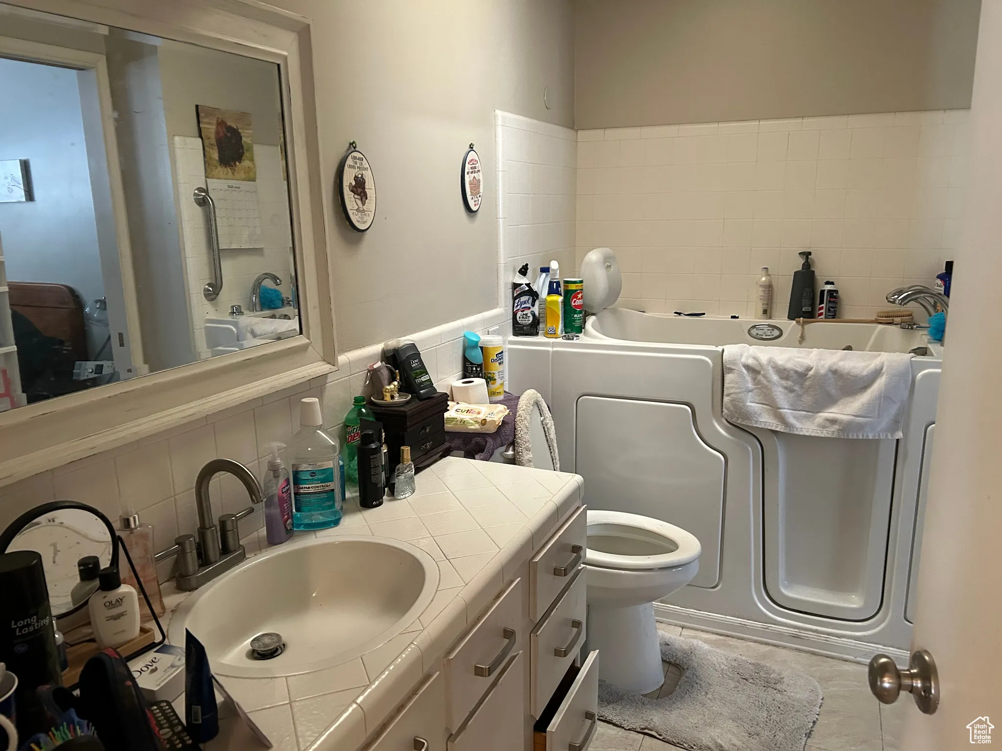 Full bathroom with a bath, vanity, toilet, and tasteful backsplash