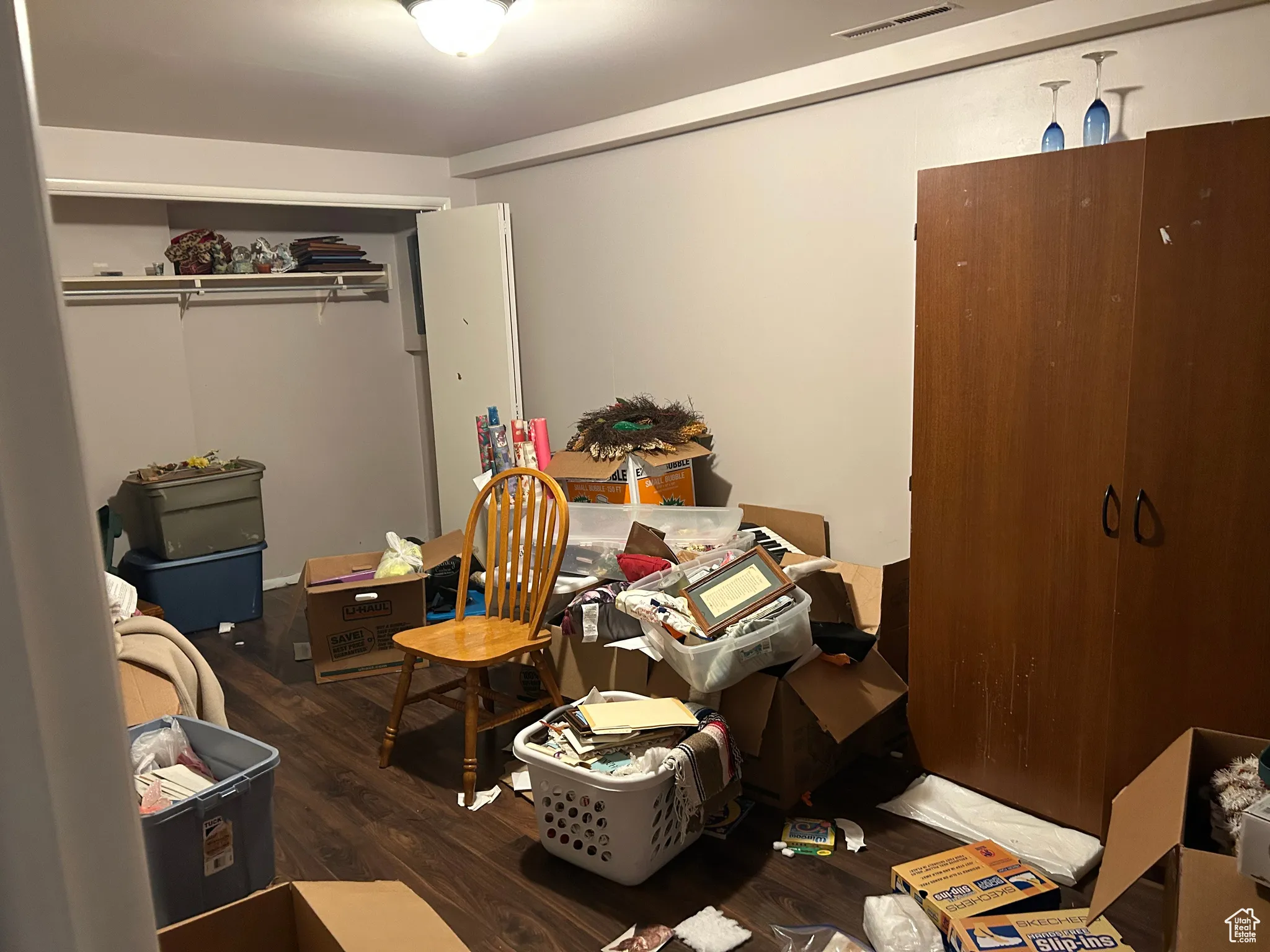 Bedroom with wood finished floors and a closet