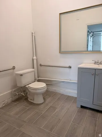 Wood-look tile flooring complementing a gray vanity with a white countertop and basin sink