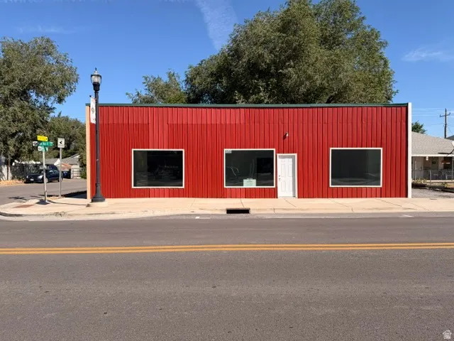 Red metal siding exterior with multiple display windows and a prominent street-facing entrance