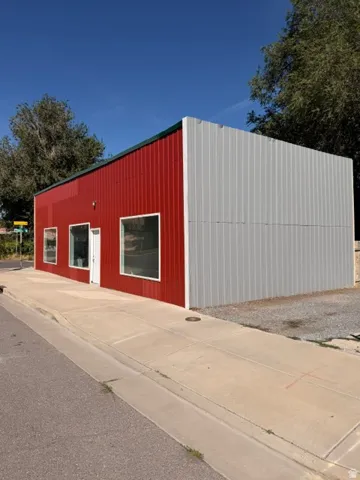 Red and gray corrugated metal exterior with a green roofline