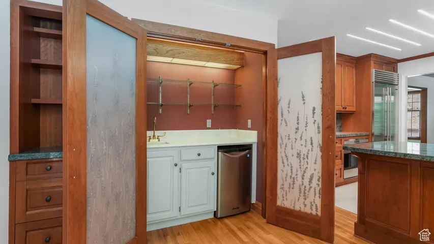 Kitchen featuring light wood-style flooring, appliances with stainless steel finishes, and open shelves