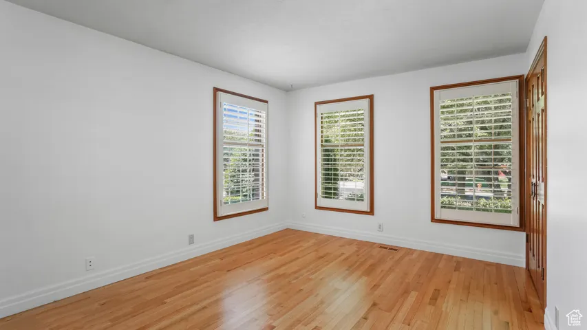Unfurnished room with light wood-style flooring and baseboards