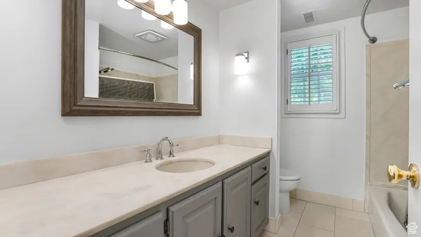Full bath with vanity, tile patterned flooring, and shower / washtub combination