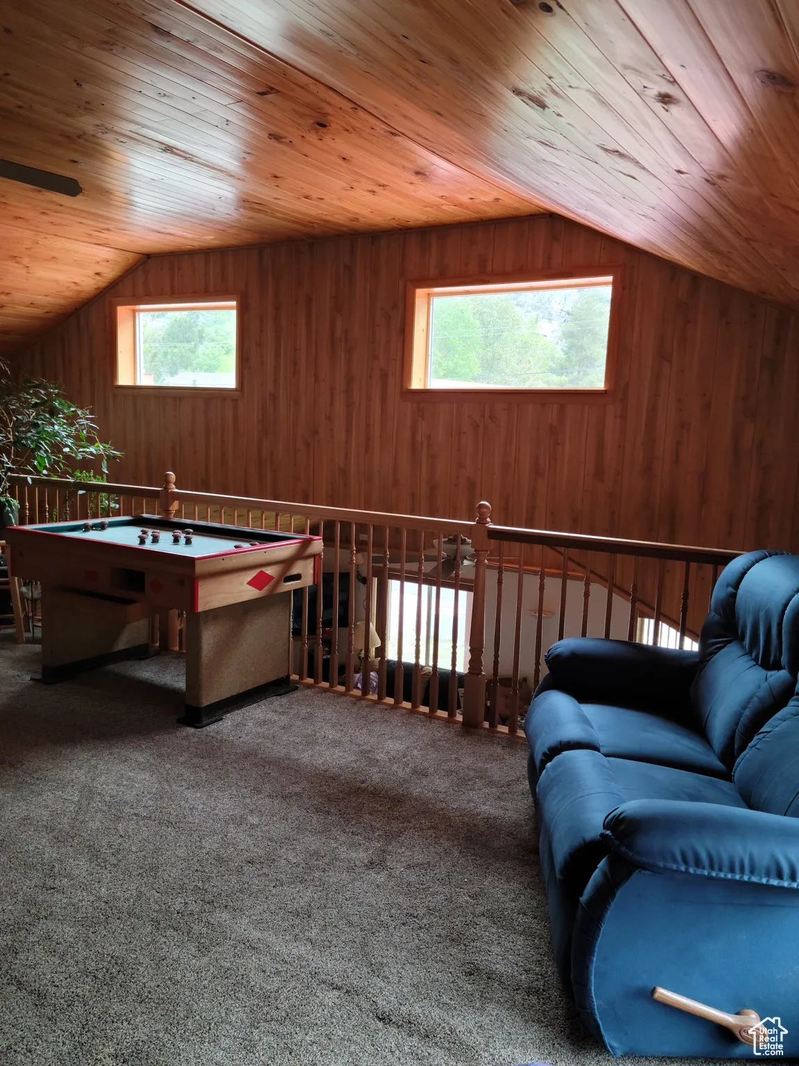 Living area featuring wood ceiling, lofted ceiling, plenty of natural light, wood walls, and carpet flooring