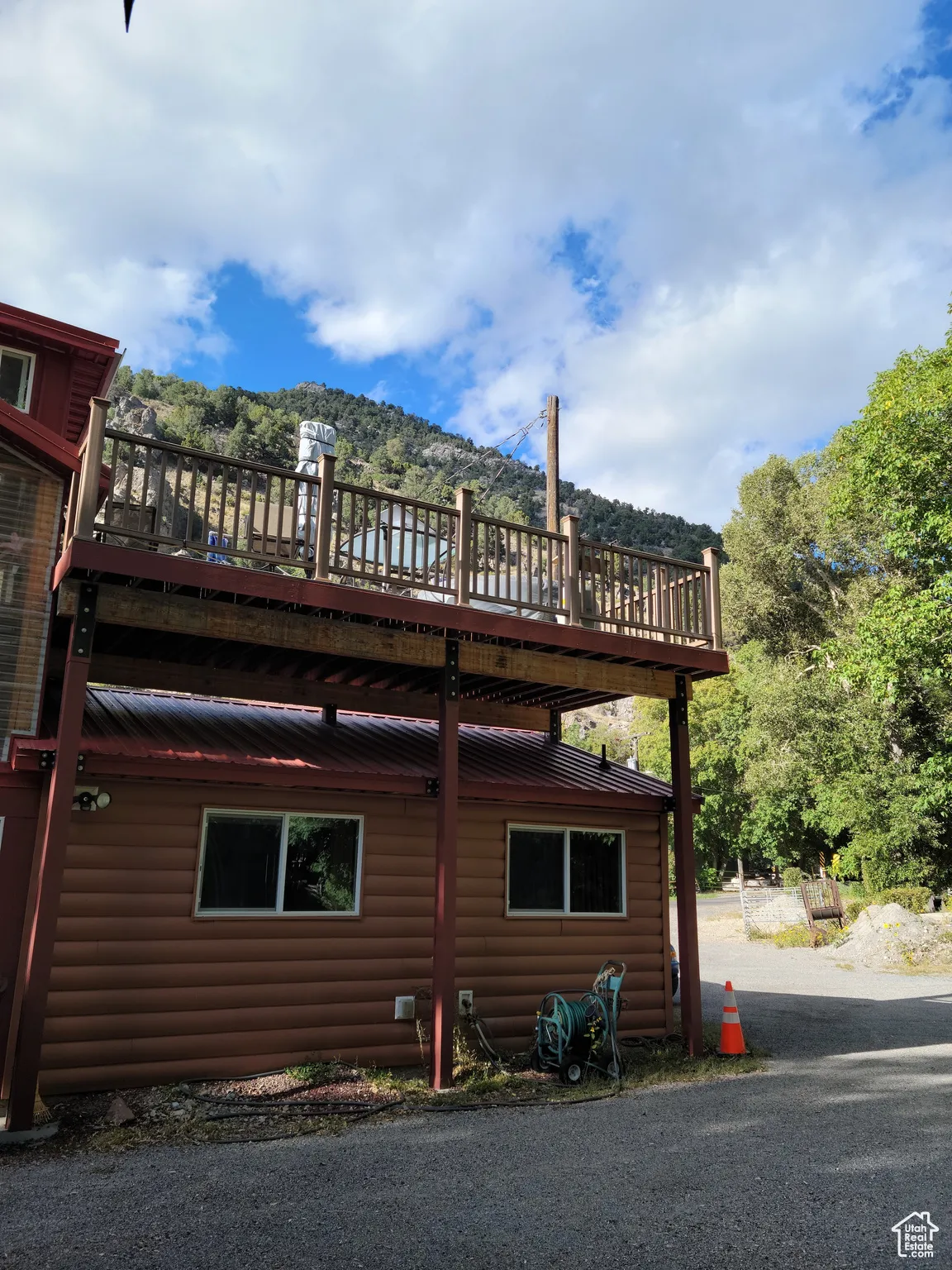 View of home's exterior with log veneer siding and a rooftop deck