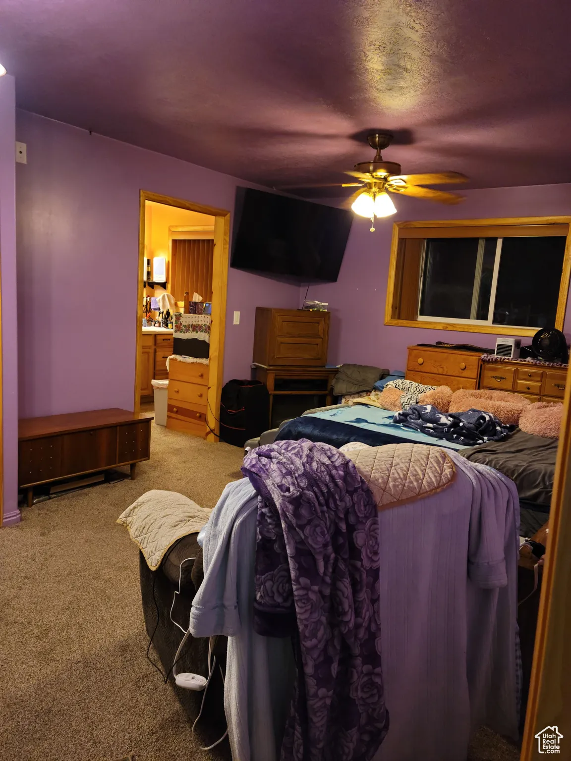 Bedroom with light carpet, connected bathroom, and ceiling fan