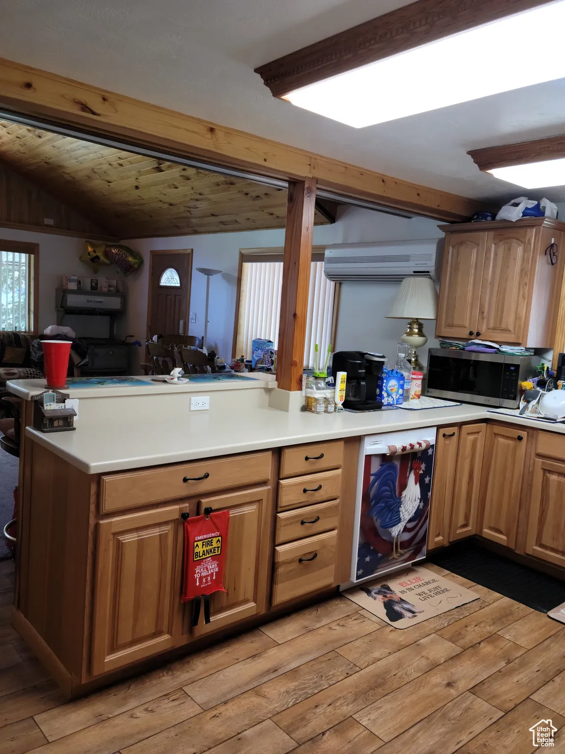 Kitchen featuring stainless steel microwave, light wood-style flooring, light countertops, and open floor plan