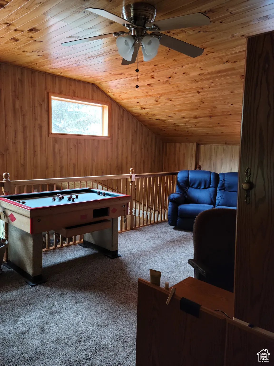 Balcony featuring wooden ceiling, ceiling fan, wood walls, lofted ceiling, and carpet