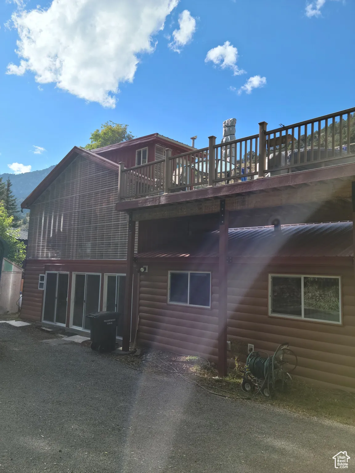 Rear view of house with sunroom and rooftop deck