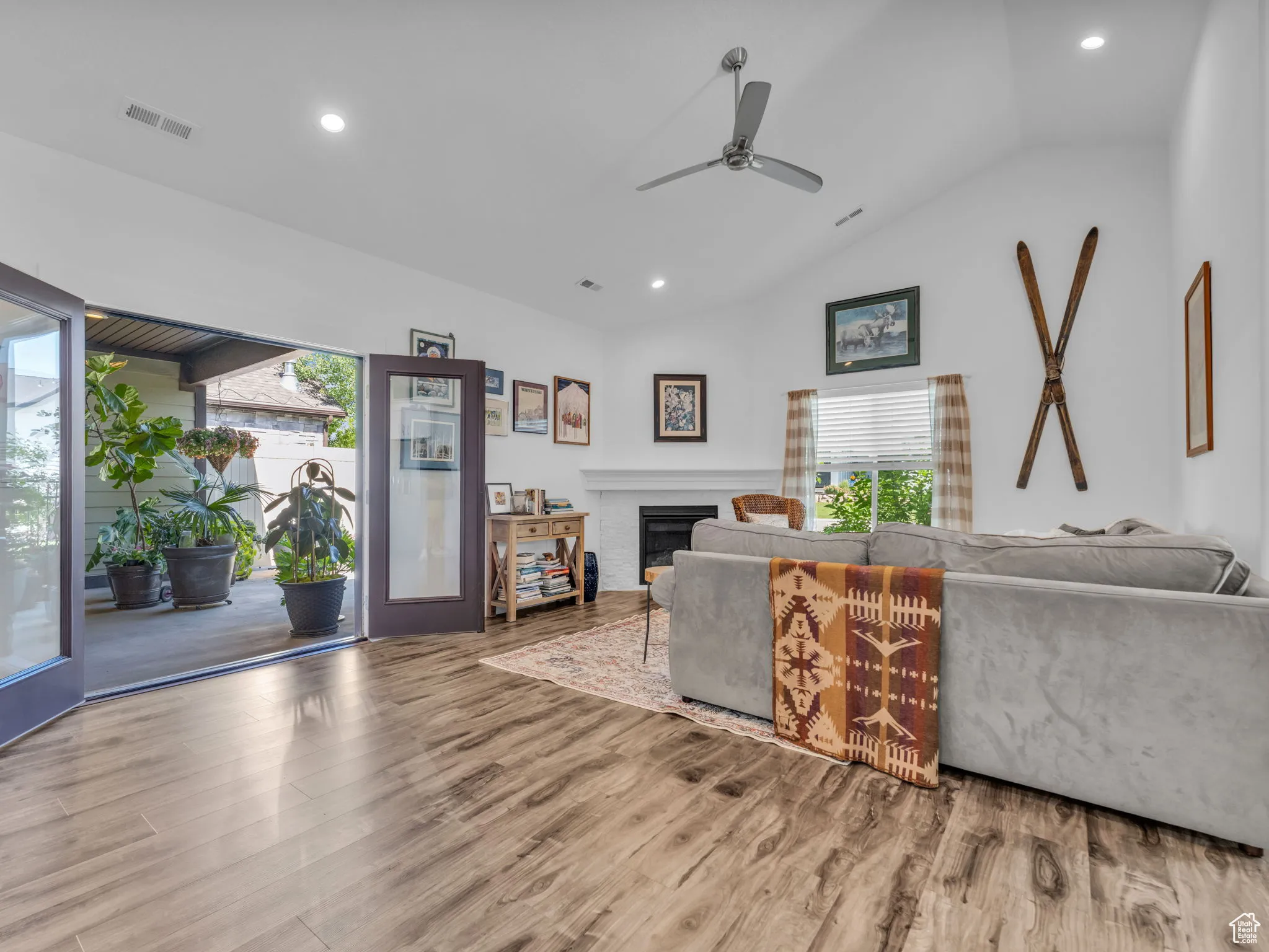 Living room with vaulted ceiling, ceiling fan, wood finished floors, plenty of natural light, and recessed lighting