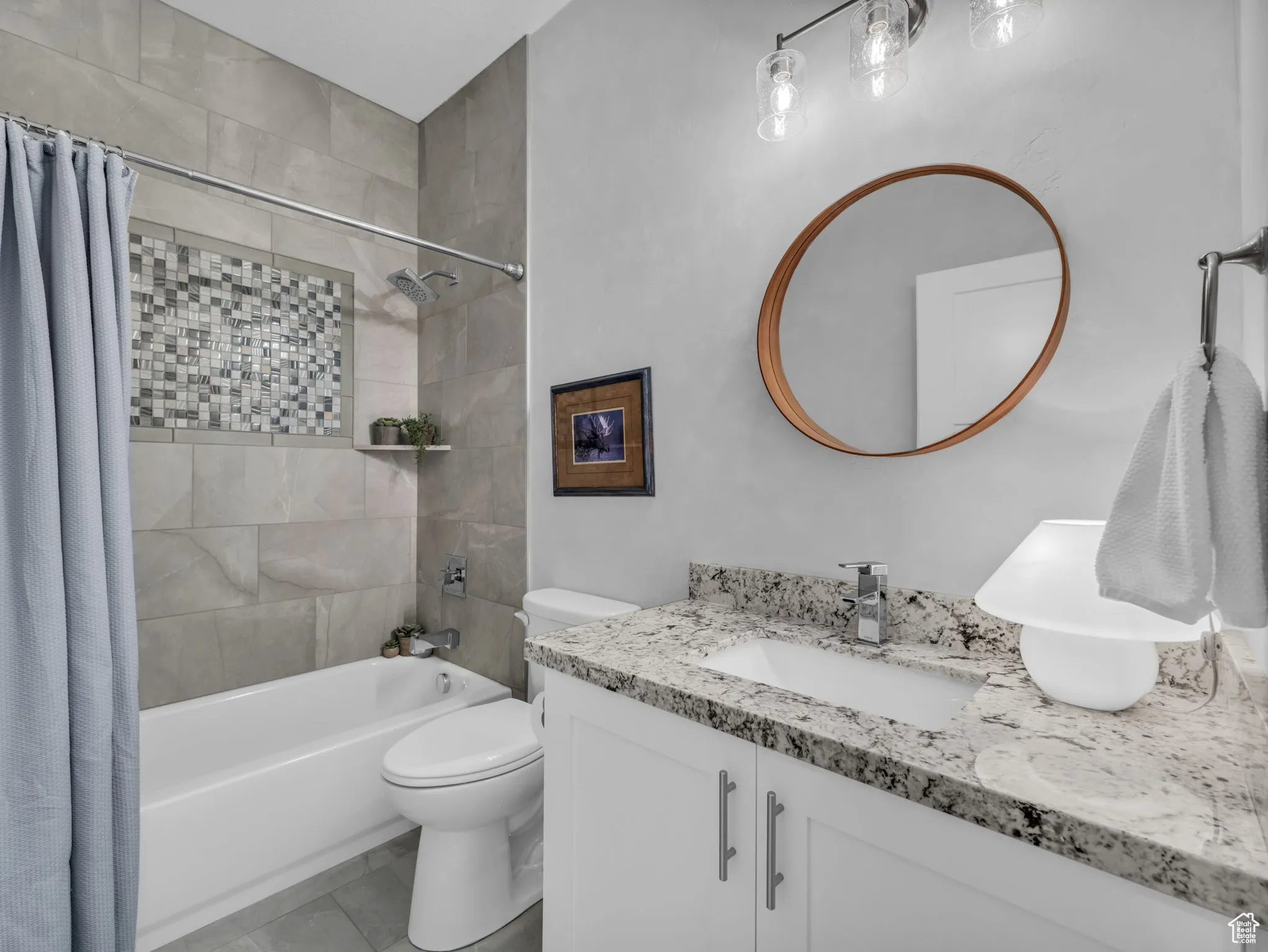 Bathroom featuring vanity and shower / bathtub combination with curtain