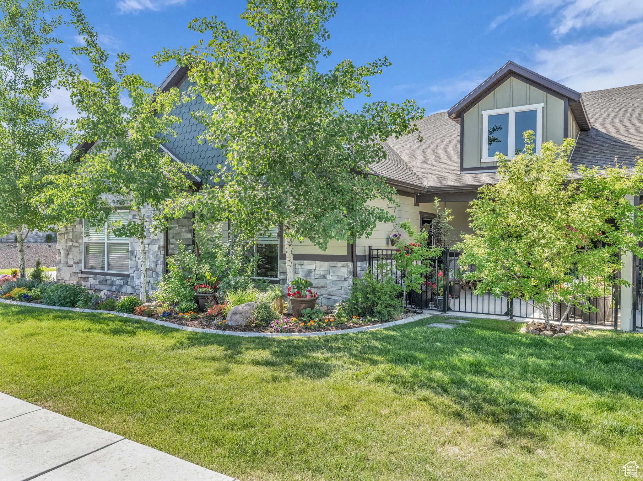 View of front of home with stone siding and a shingled roof