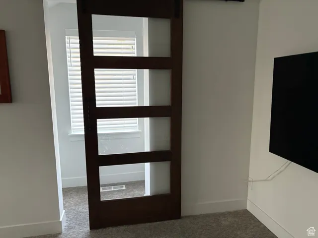 Foyer entrance featuring carpet floors and a barn door