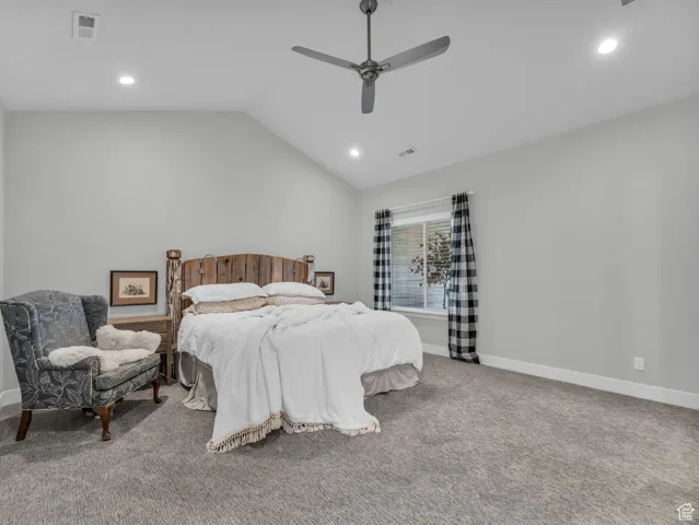 Carpeted bedroom featuring recessed lighting, vaulted ceiling, and a ceiling fan