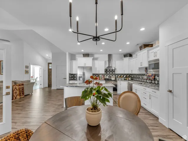 Dining area with recessed lighting, light wood-style floors, and a chandelier