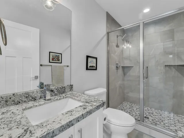 Full bath featuring vanity, a stall shower, and recessed lighting
