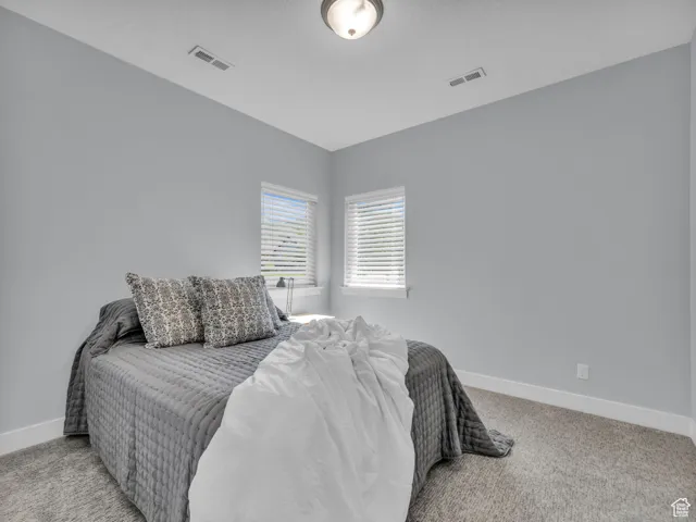 Bedroom featuring light carpet