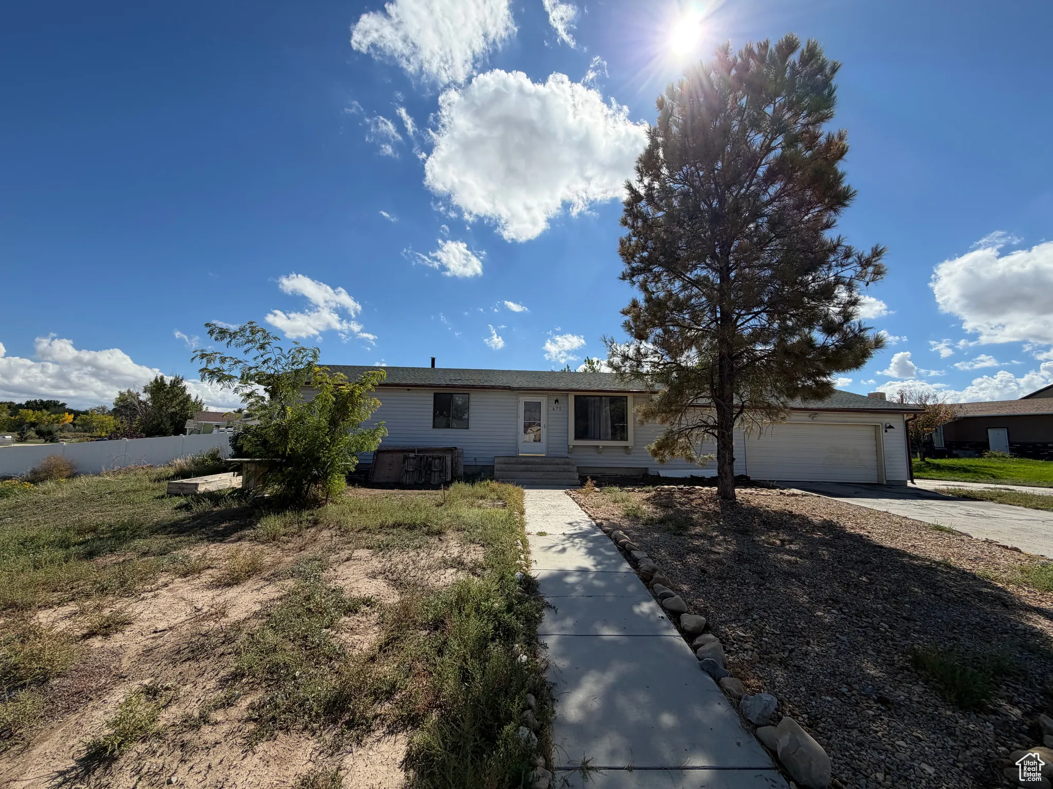 Single story home featuring concrete driveway, a garage, and entry steps