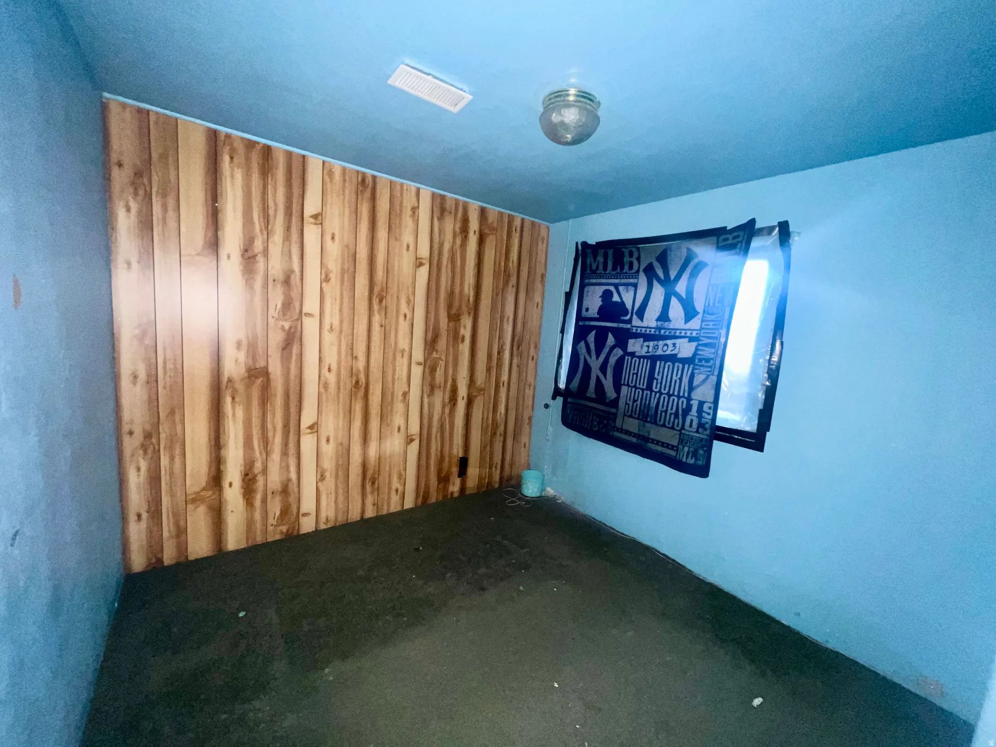 Empty room featuring carpet floors and wooden walls