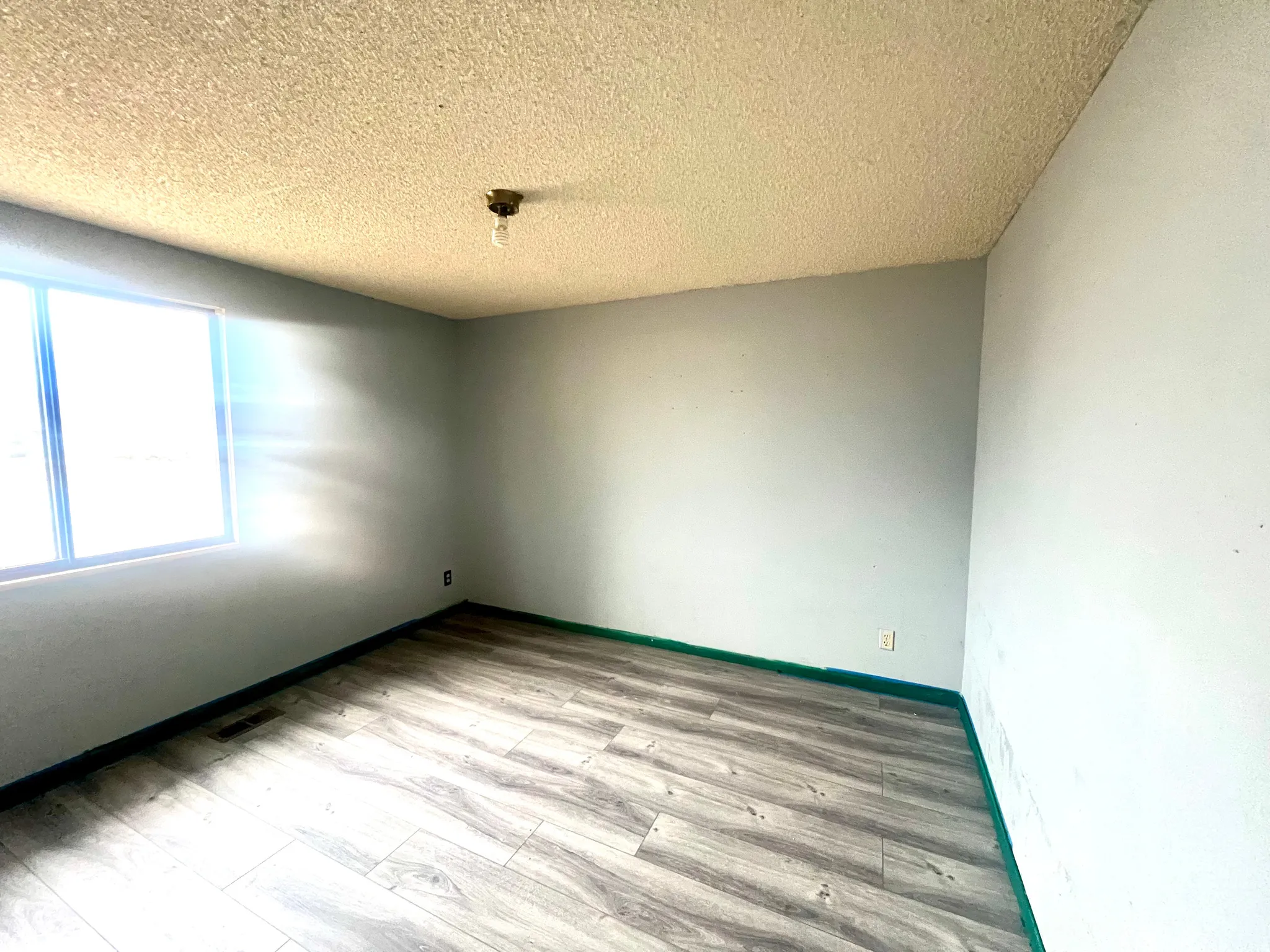 Spare room featuring a textured ceiling and light wood finished floors