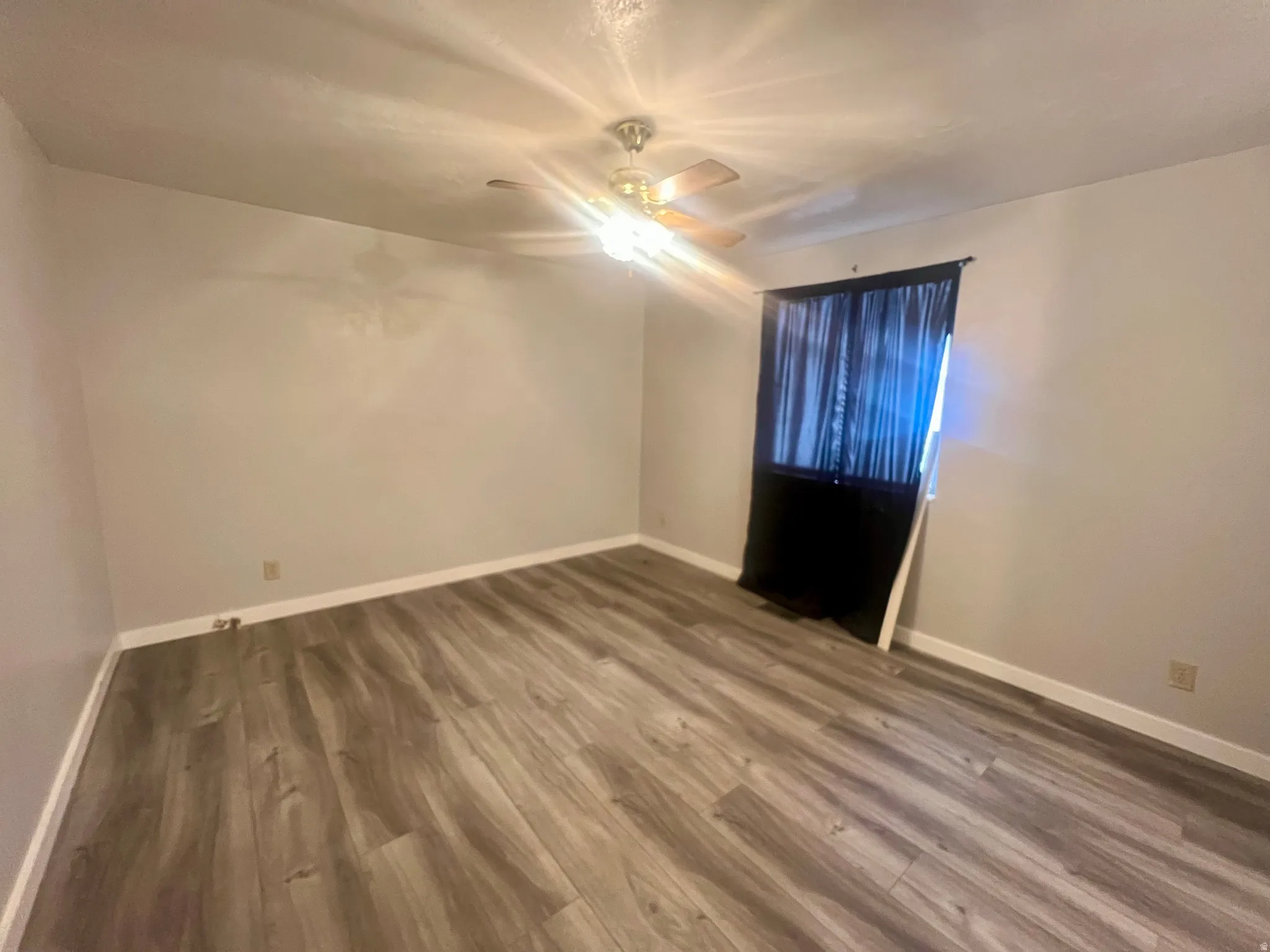Unfurnished room with wood finished floors and ceiling fan