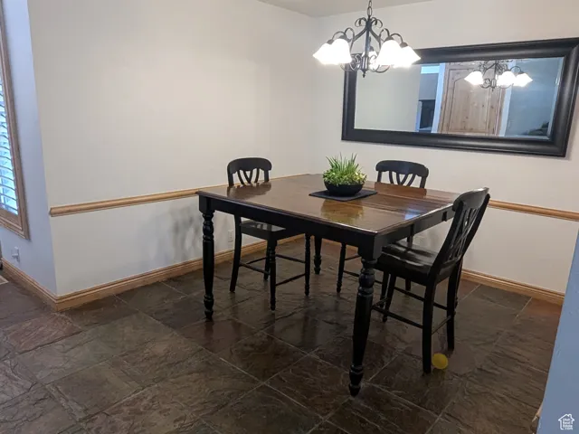 Dining room featuring stone tile flooring and a chandelier