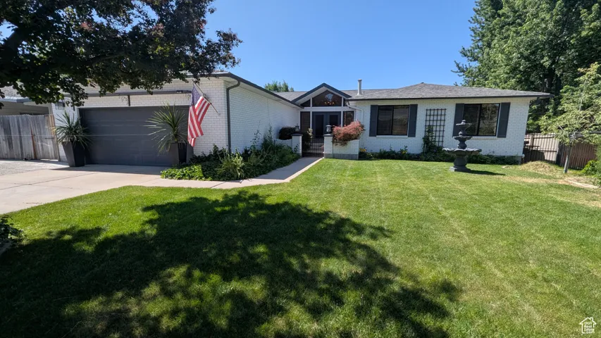 View of front facade featuring brick siding, concrete driveway, and a garage
