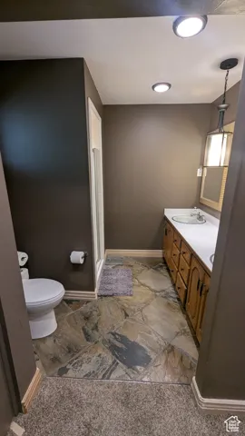 Master bathroom featuring vanity, stone finish flooring, and a stall shower
