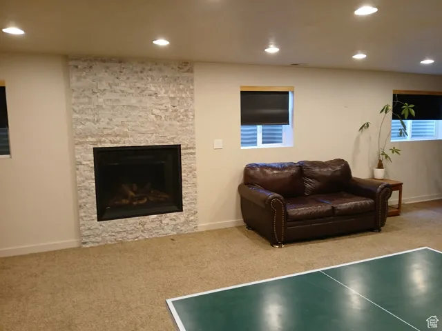 Living room featuring carpet, recessed lighting, and a fireplace