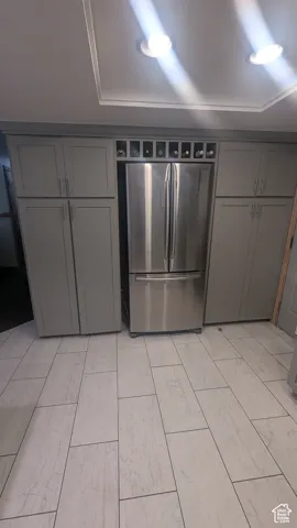 Kitchen featuring freestanding refrigerator, gray cabinetry, and light wood-style flooring