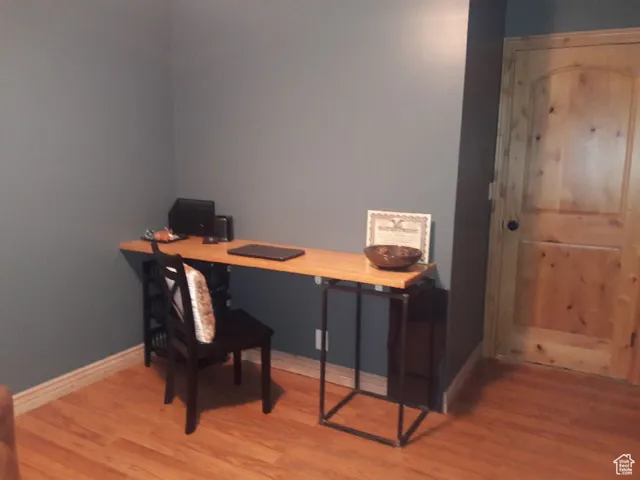 Office space with light wood-style flooring and baseboards