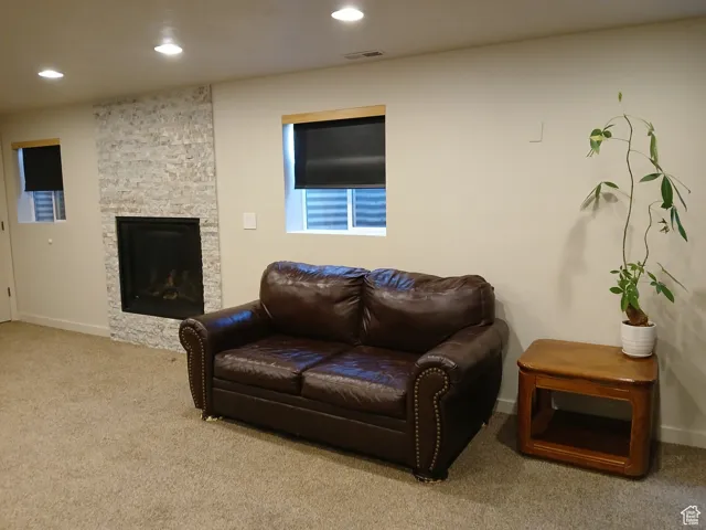 Living room featuring carpet flooring, recessed lighting, and a fireplace