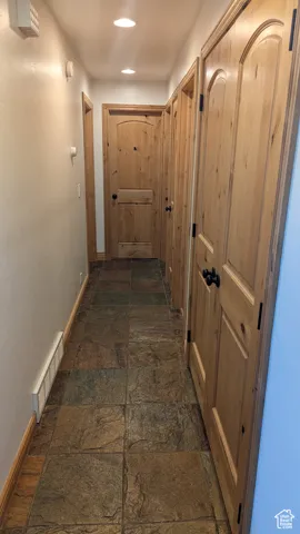 Corridor with stone tile flooring and recessed lighting