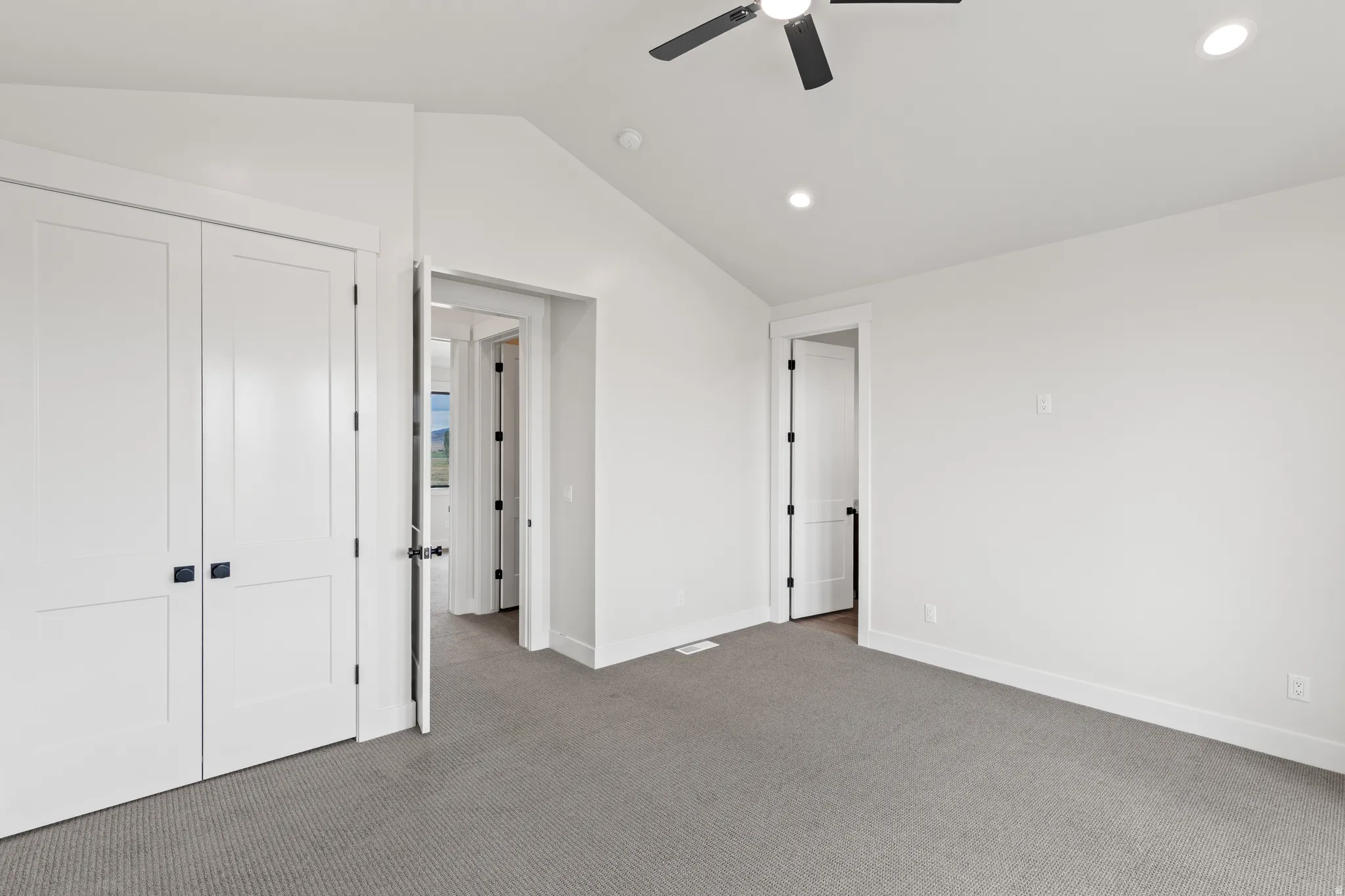Vaulted ceiling with a ceiling fan, recessed lighting, white trim, and gray carpet flooring