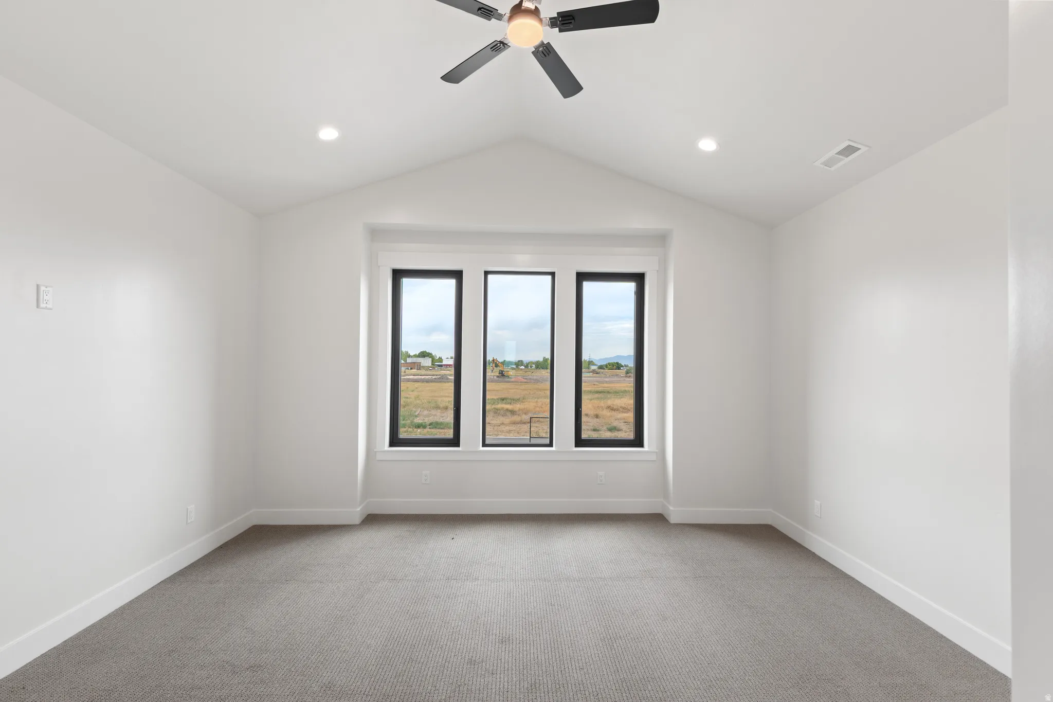Vaulted ceiling featuring a ceiling fan and recessed lighting, with carpeted flooring