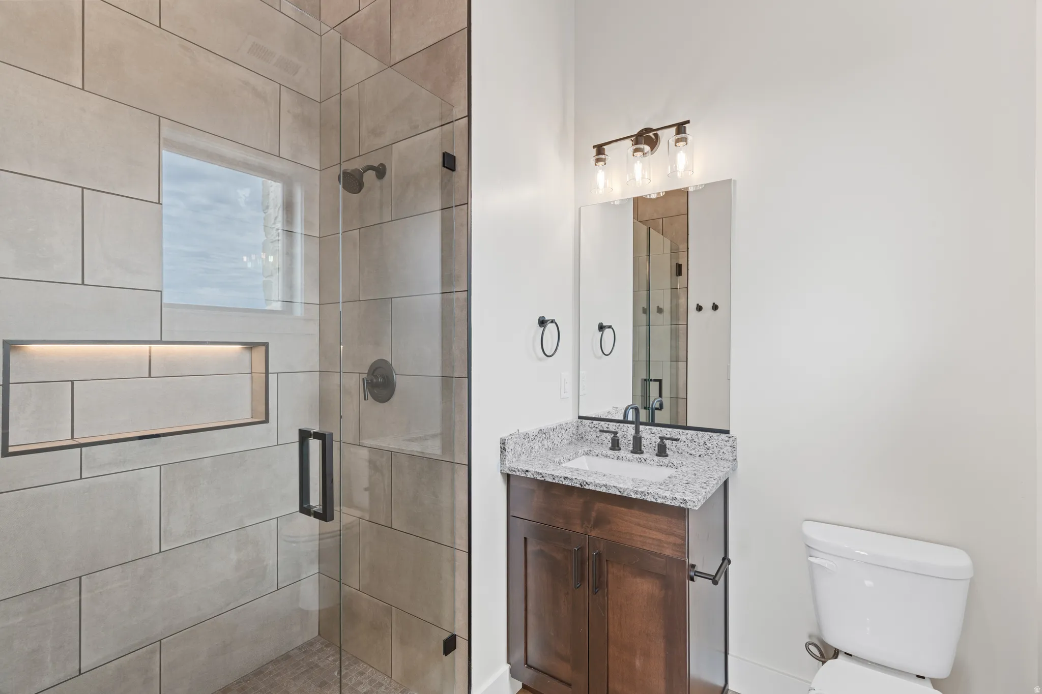 Walk-in shower with large format tile and built-in niche