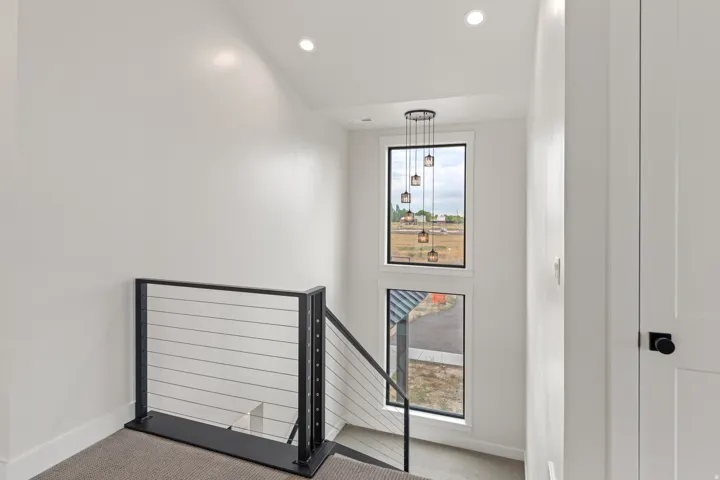 Modern cable railing system, recessed ceiling lighting, multi-pendant light fixture, and vertical window design