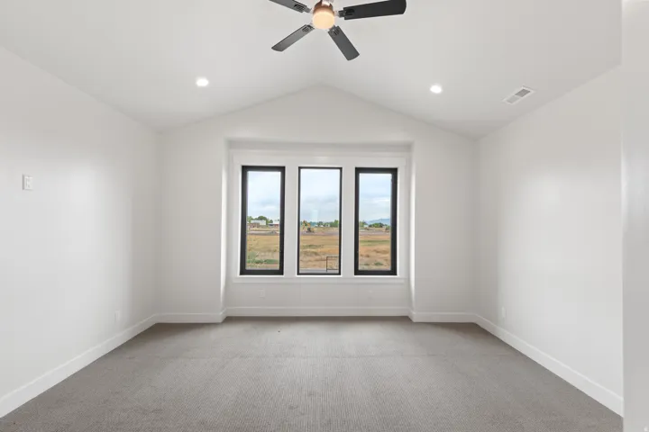 Vaulted ceiling featuring a ceiling fan and recessed lighting, with carpeted flooring