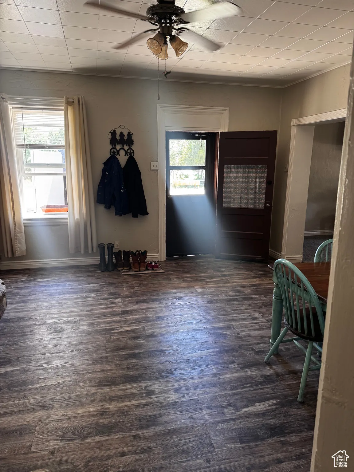 Empty room featuring a ceiling fan and dark wood-style floors