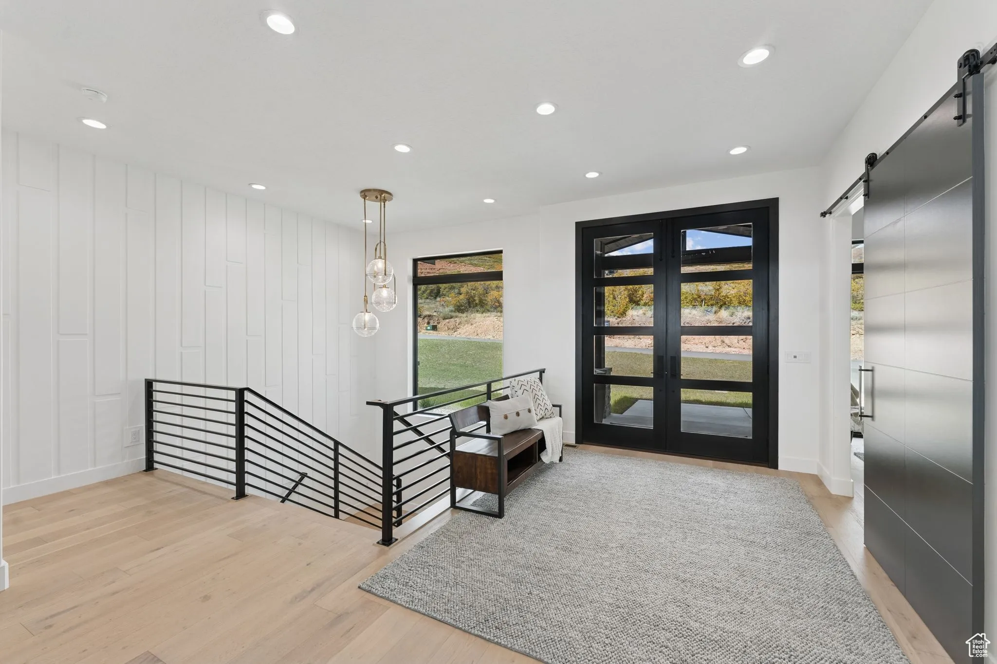 Entrance foyer featuring a barn door, light wood-style flooring, and recessed lighting