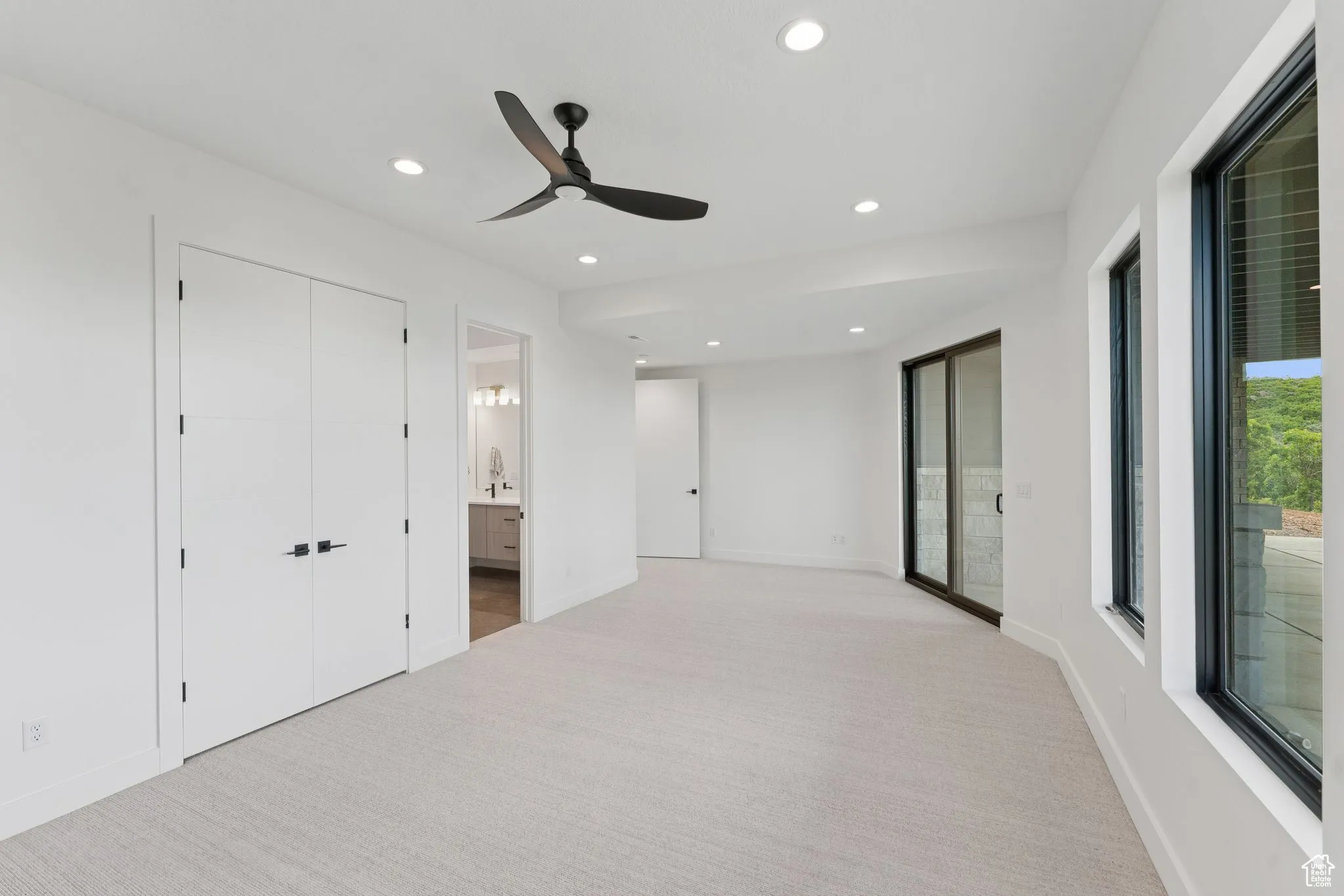 Unfurnished bedroom with light colored carpet, recessed lighting, connected bathroom, and ceiling fan