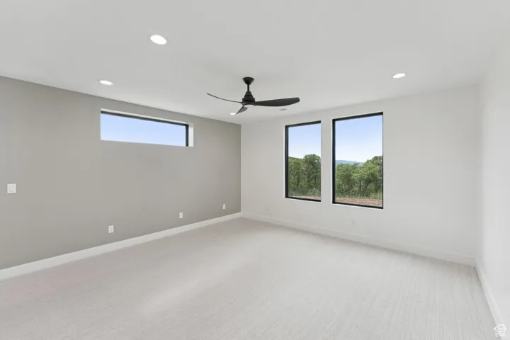 Spare room with light carpet, recessed lighting, and a ceiling fan